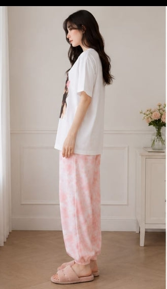 Side view of relaxed white T-shirt and pink checked cuffed pyjama bottoms