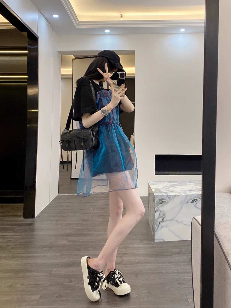 Full outfit view of black oversized T-shirt with blue sheer overlay