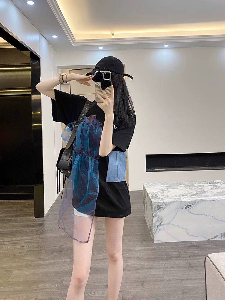 Angled view of black oversized T-shirt with blue sheer overlay