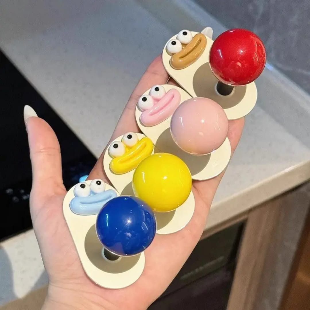 Single yellow cartoon face self adhesive wall hook close-up