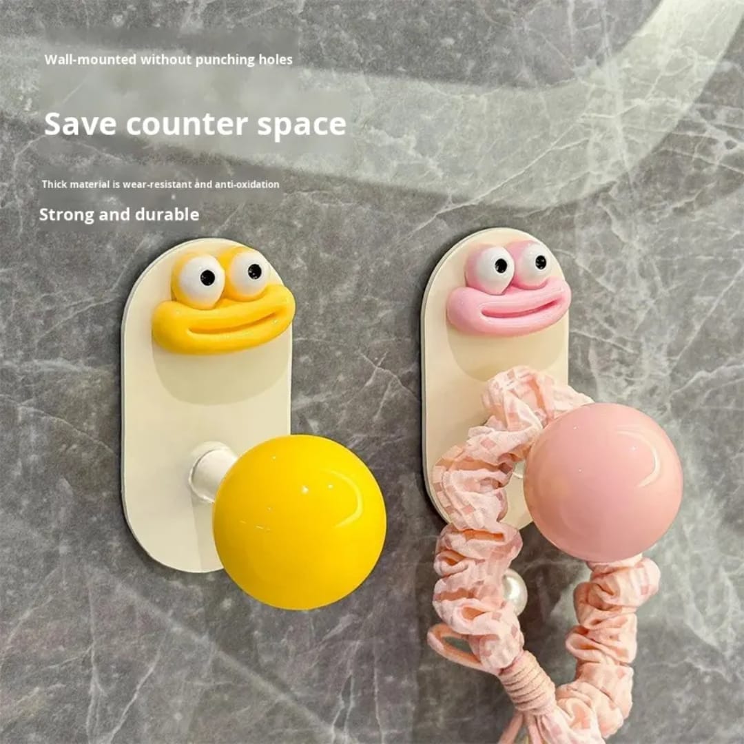 Yellow and Pink cartoon hooks holding scrunchie and accessories on wall