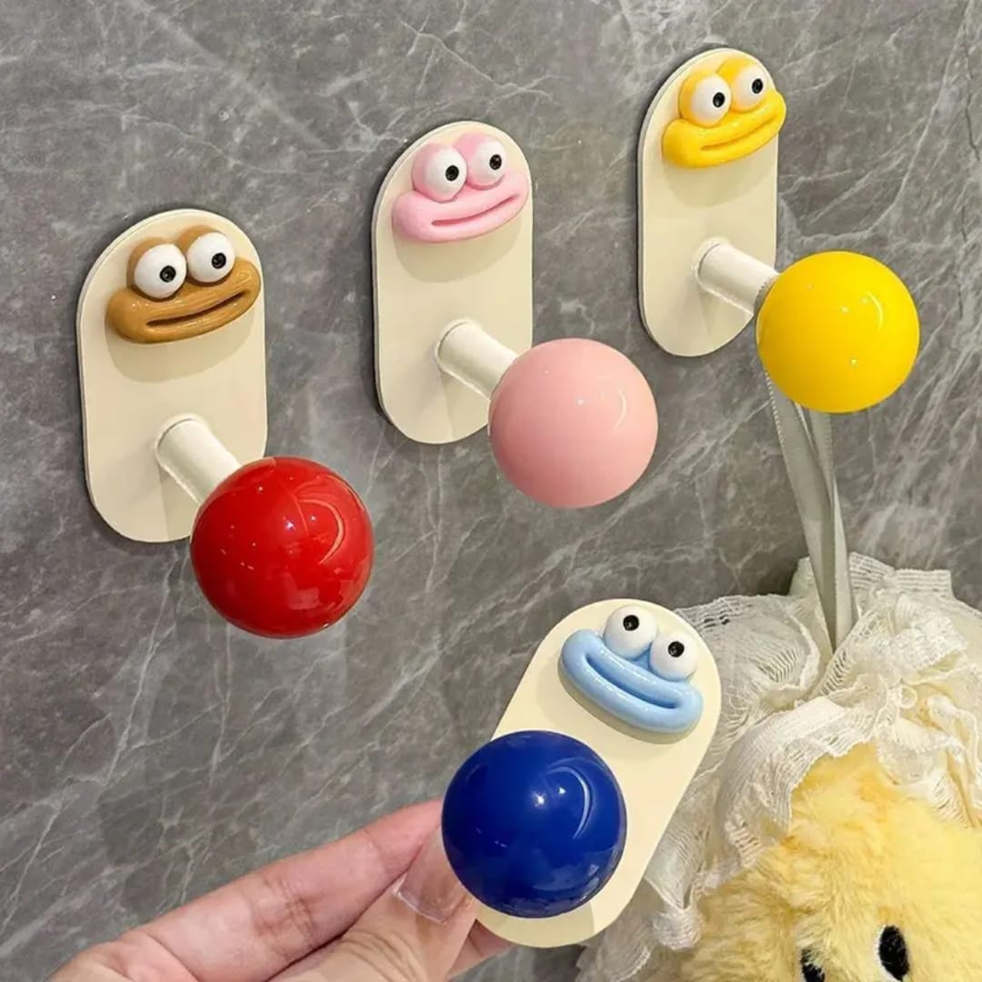 Pack of 4 cartoon face hooks in Blue, Yellow, Pink and Red held in hand